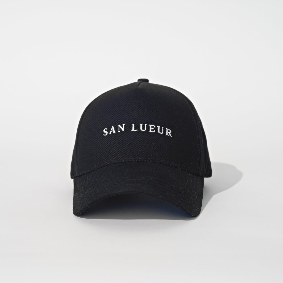 A black baseball cap with 'SAN LUEUR' embroidered in white capital letters on the front, set against a clean white background.