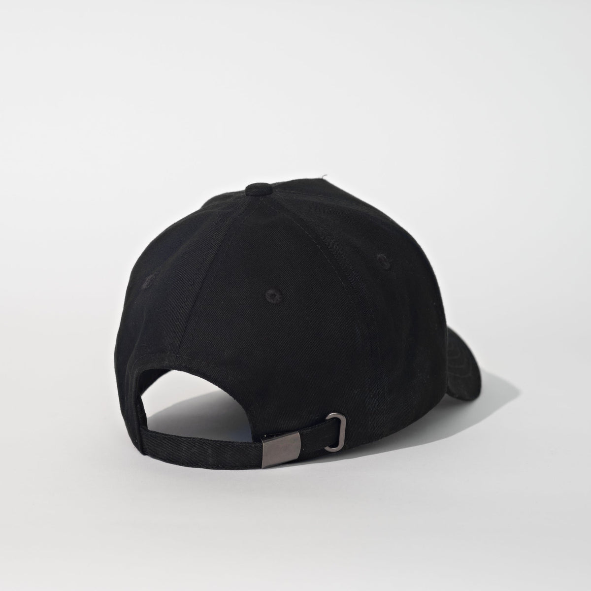A black baseball cap shown from a three-quarters back angle on a light gray studio background.