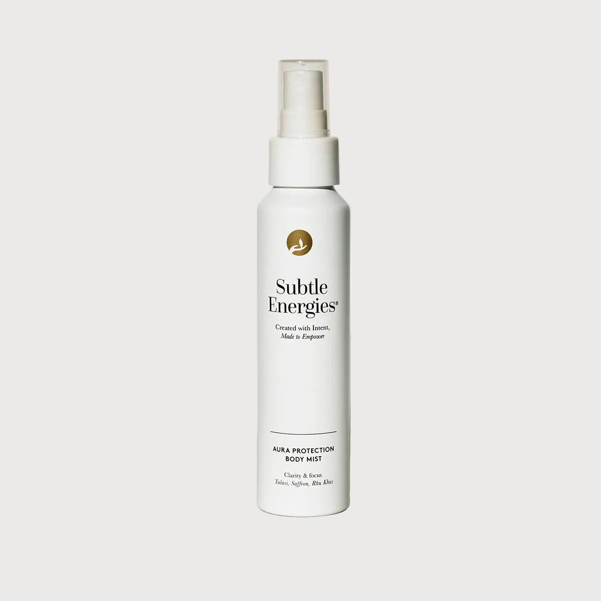 White spray bottle labeled 'Subtle Energies' on a beige surface with a light gray background