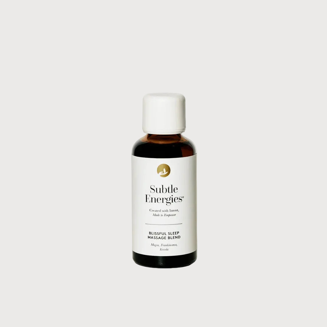Bottle of Subtle Energies massage blend on a light surface with a white background