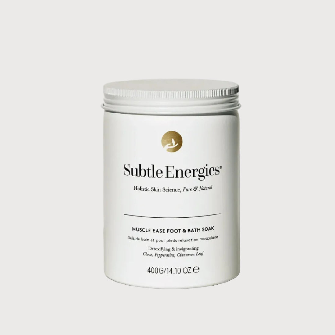 A white plastic jar of Subtle Energies Muscle Ease Foot and Bath Soak with a white screw cap, set on a light beige surface against a white background with a soft shadow.