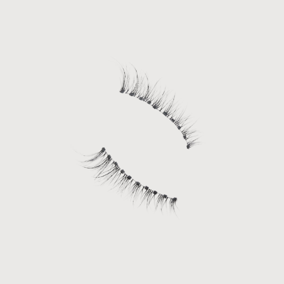 Pair of false eyelashes on a light gray background