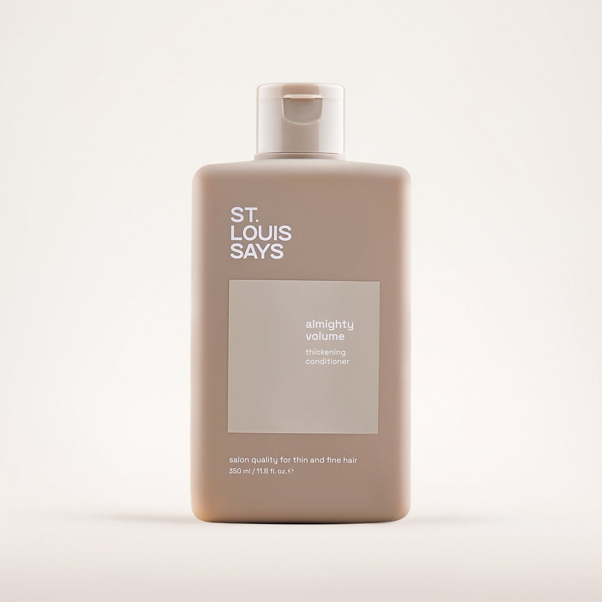 Shampoo bottle labeled 'St. Louis Says' on a light beige background