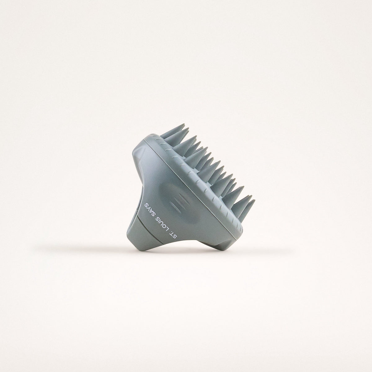 Blue scalp massager on a light beige background