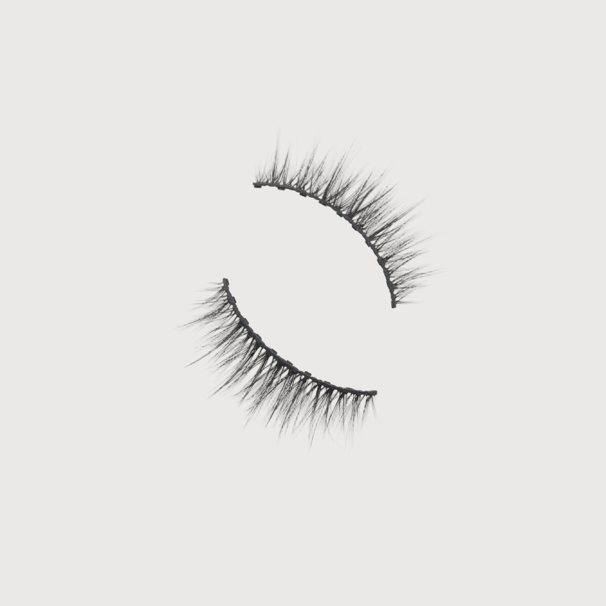 Pair of false eyelashes on a light gray background