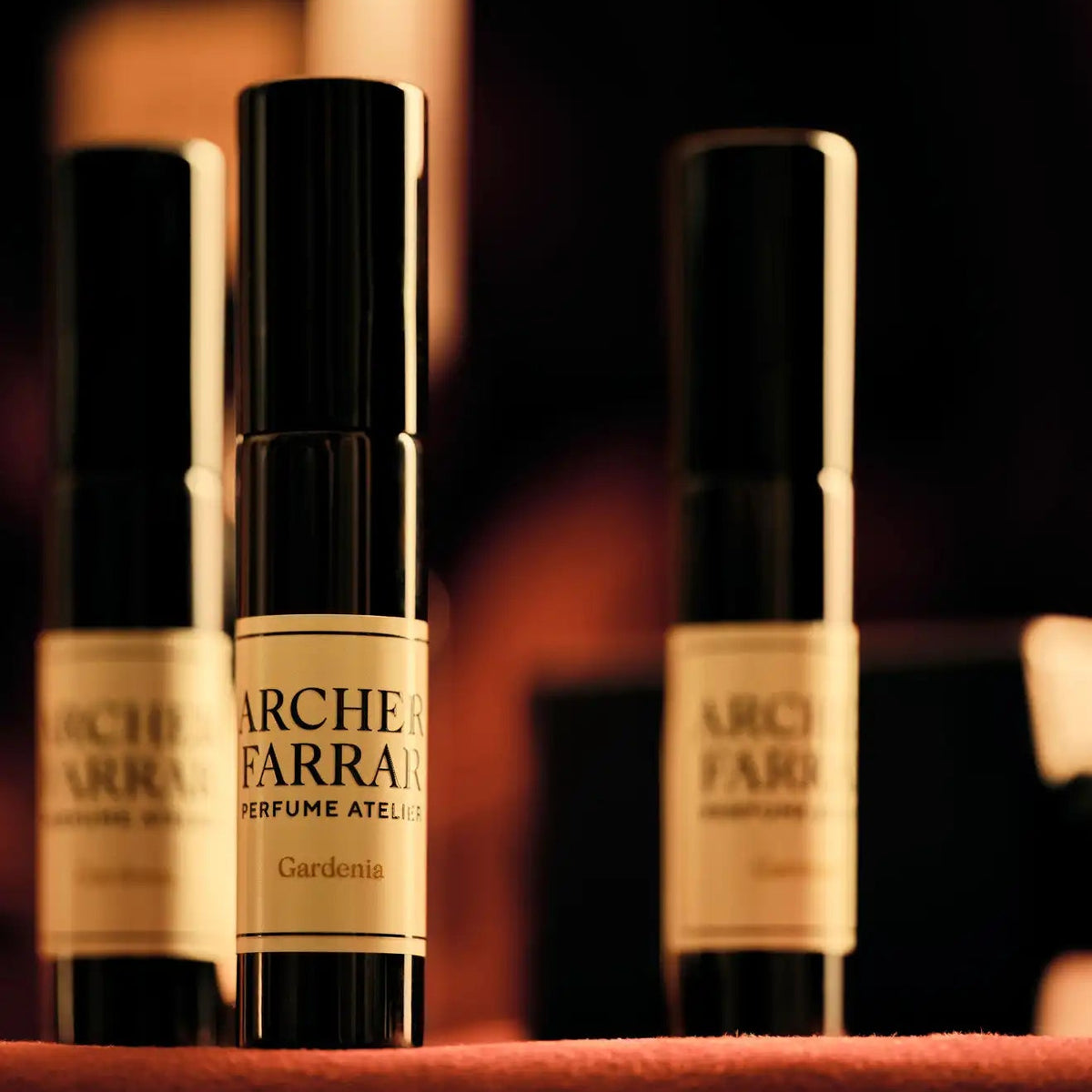 Three Archer Farrar perfume bottles on a dark background
