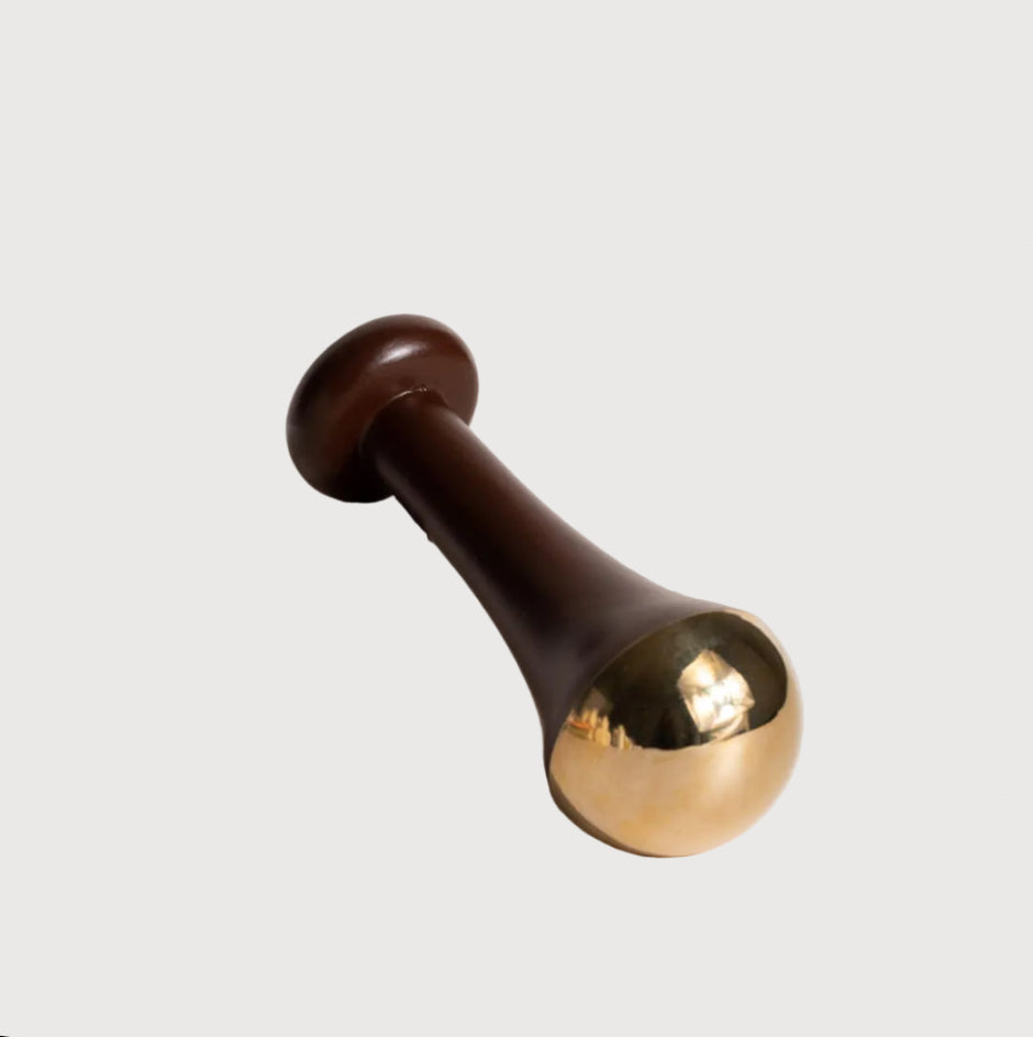 Decorative object with a brown and gold finish on a light background