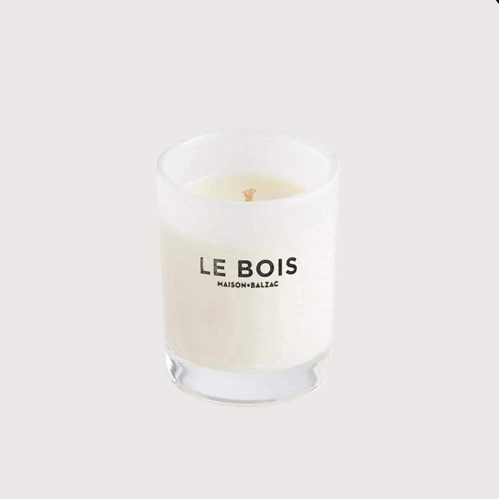 Candle with 'Le Bois' branding on a white background