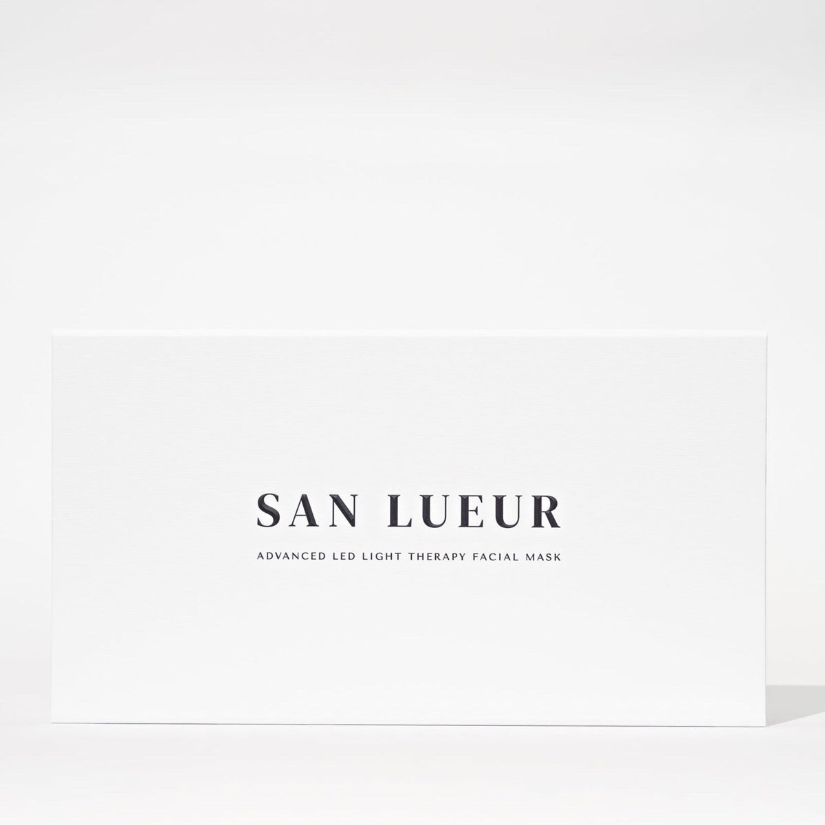 A white rectangular box with black text reading 'SAN LUEUR' and smaller text 'ADVANCED LED LIGHT THERAPY FACIAL MASK' on a clean white background.