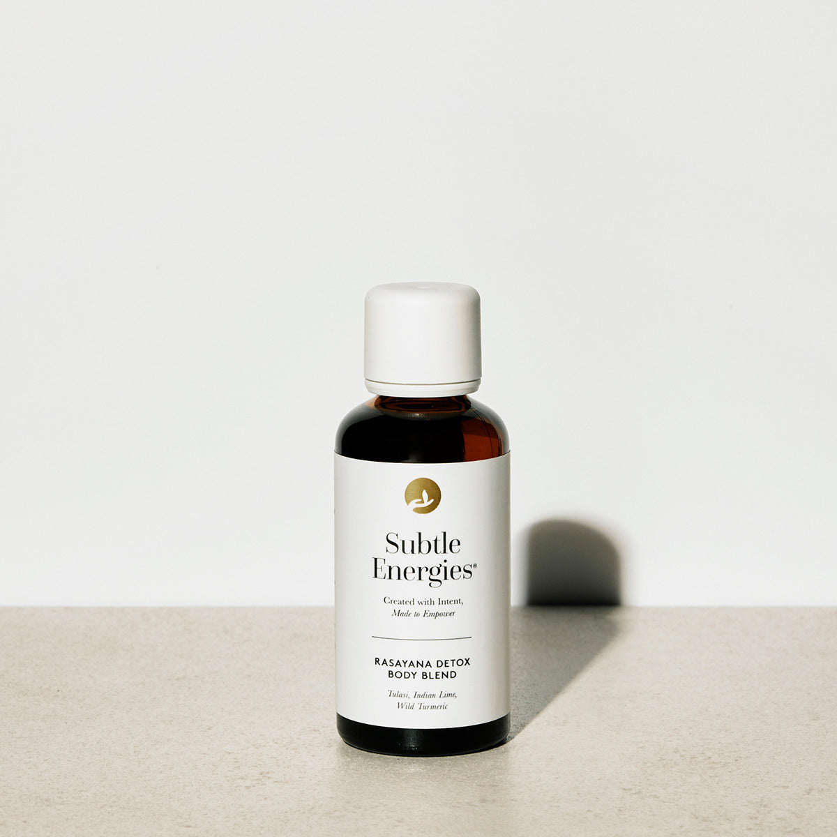 Bottle of Subtle Energies Rasayana Detox Body Blend on a light surface with a white background