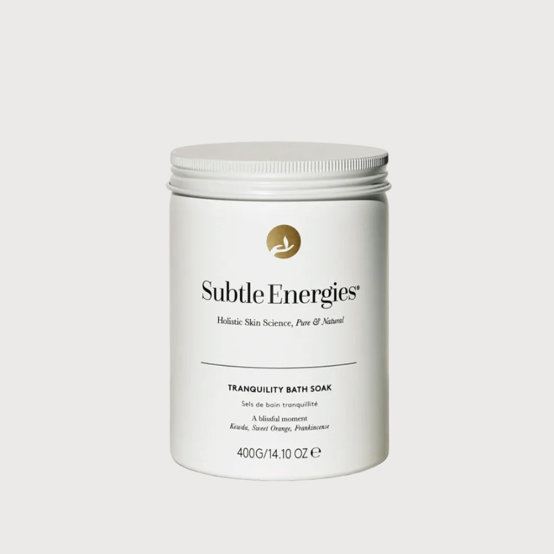 A white cylindrical metal tub of Subtle Energies Tranquility Bath Soak with a ribbed screw-top lid, set on a light beige surface against a white background with a soft shadow.
