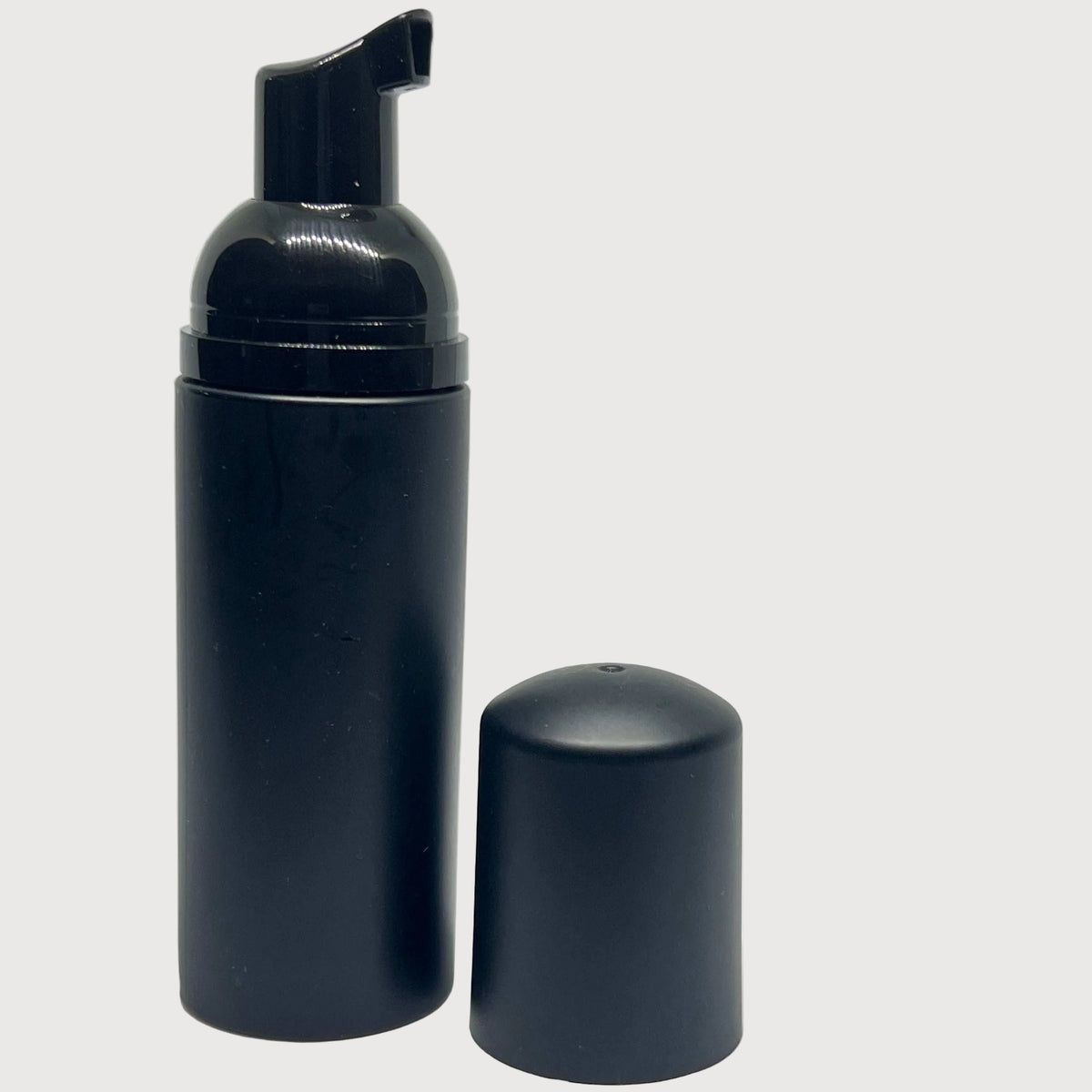 Black foam bottle with pump and cap on a white background