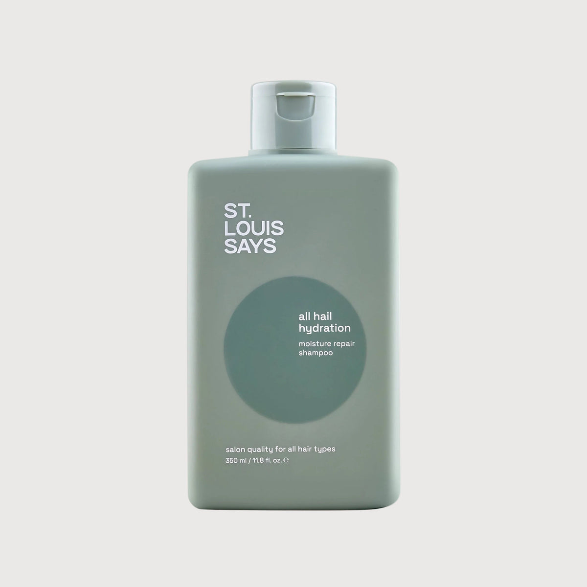 Bottle of 'St. Louis Says' hair product on a light gray background