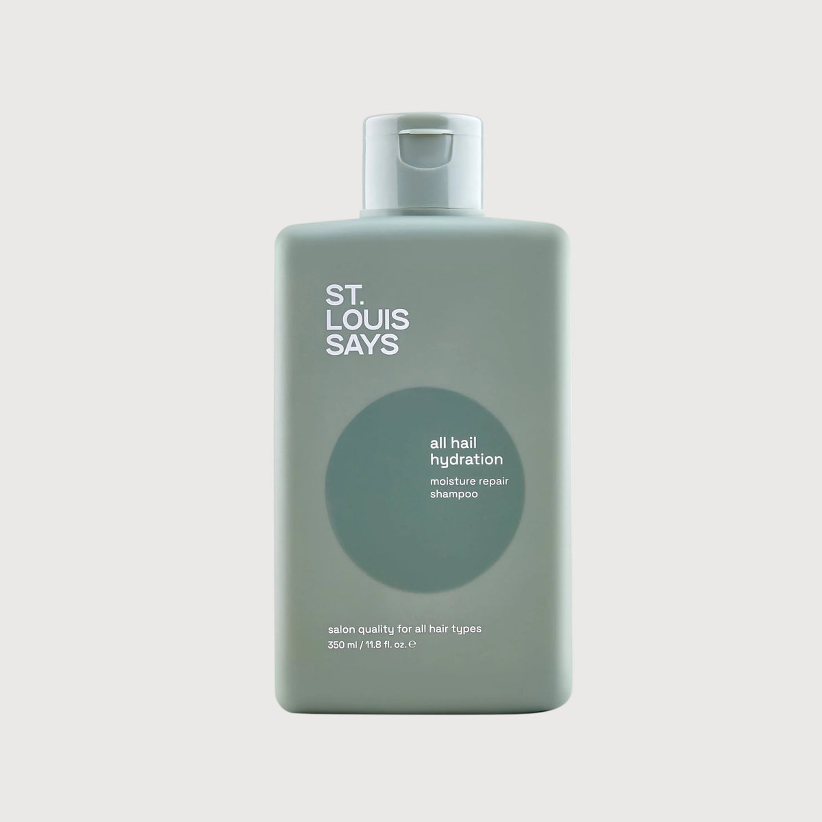 Bottle of 'St. Louis Says' hair product on a light gray background