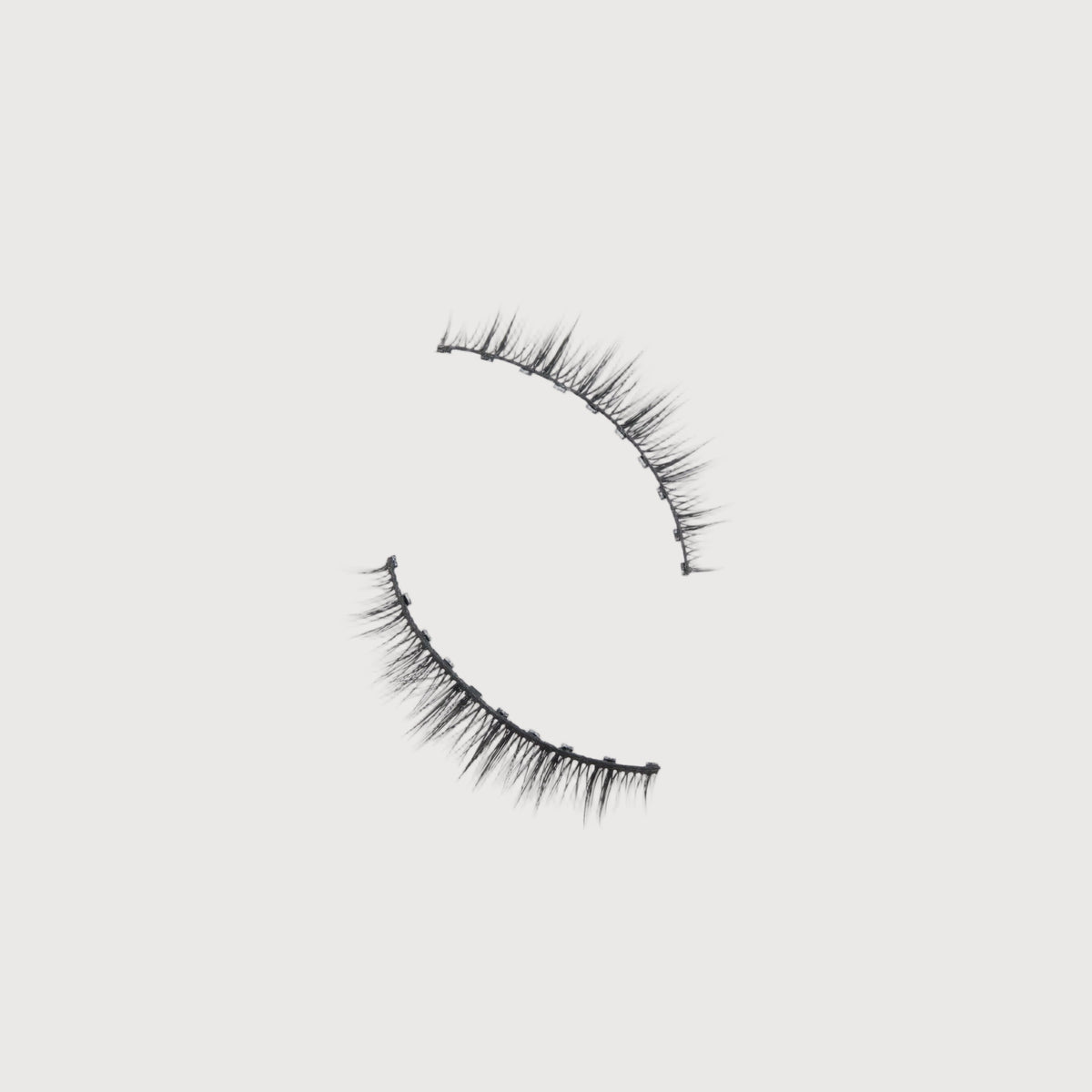 Pair of false eyelashes on a light gray background