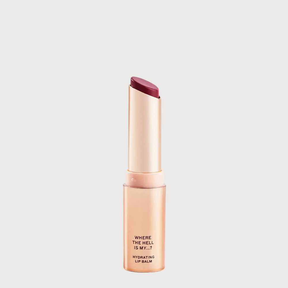 Lip balm with a gold casing and red cap on a light gray background
