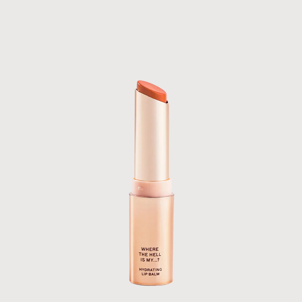 Lip balm with orange cap and visible text on a light gray background
