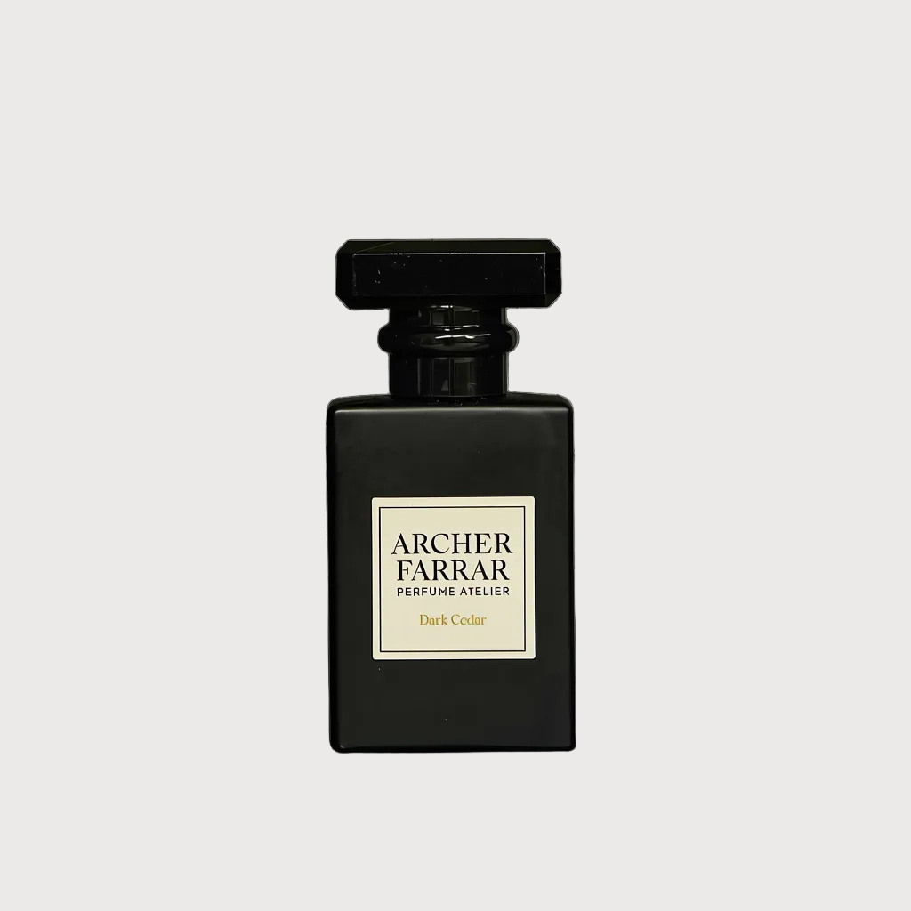A dark glass perfume bottle with a black cap and a cream-colored label reading 'ARCHER FARRAR PERFUMES ATTELIER' and 'Dark Color'.