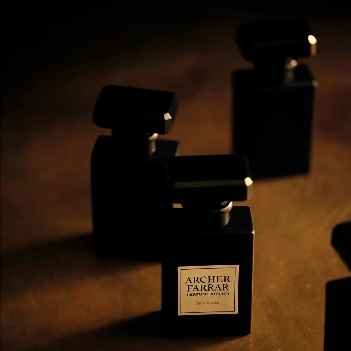 Perfume bottles with 'Archer Farrar' label on a dark background