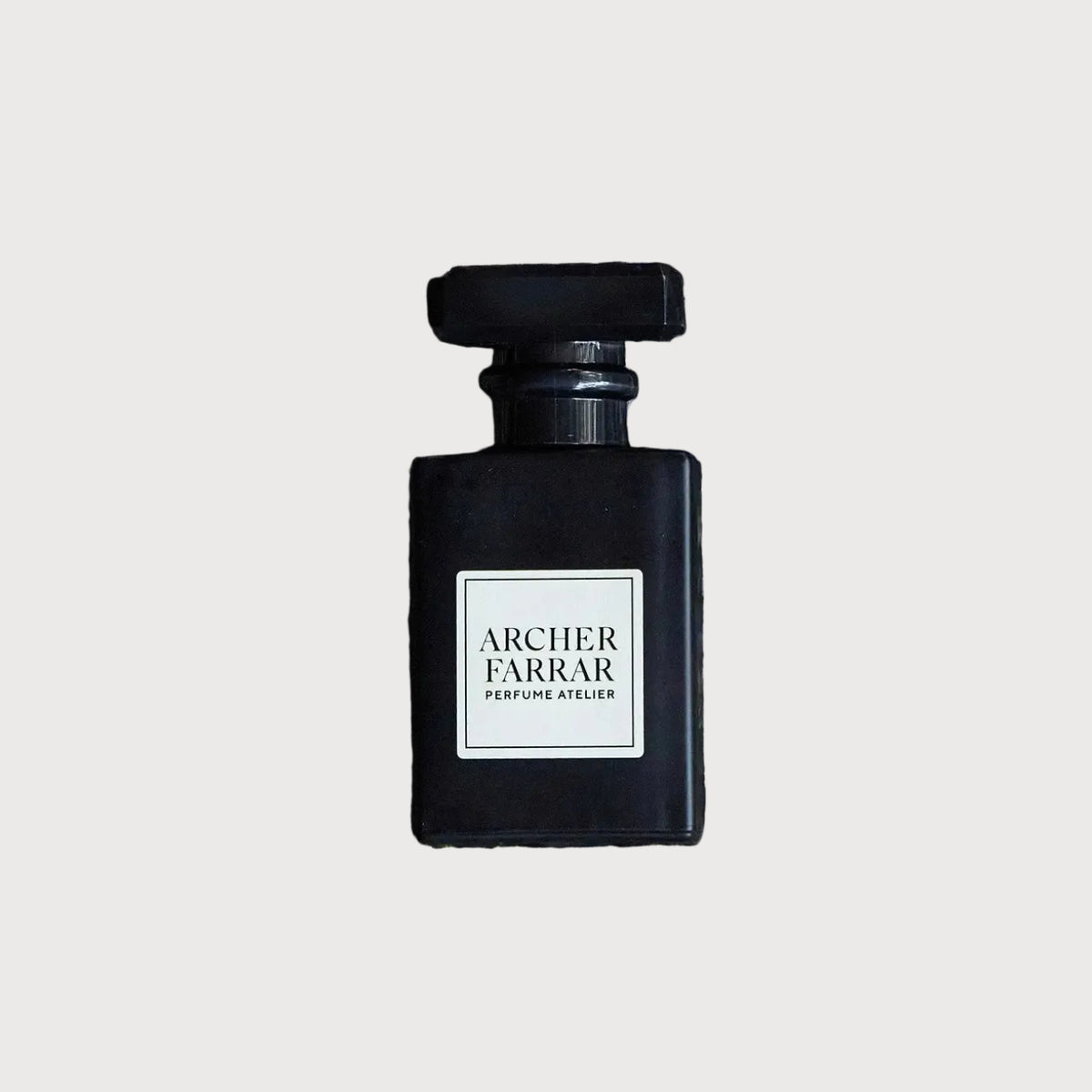 Black perfume bottle with 'Archer Farrar' label on a background of lavender flowers