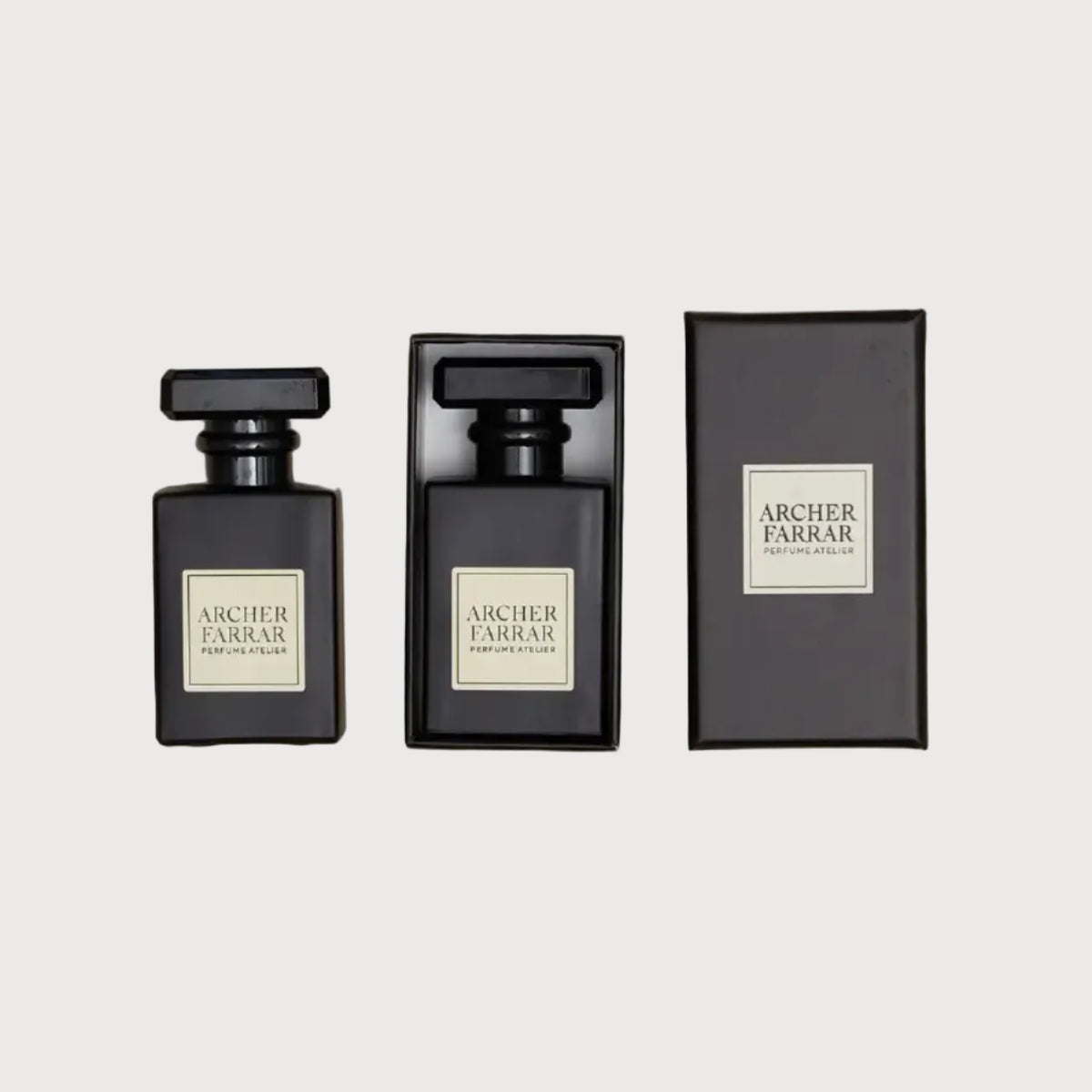 Three black perfume bottles with 'Archer Farrar' labels on a beige marble background