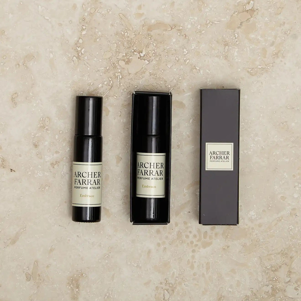 Two Archer Parker perfume bottles and their packaging on a textured beige surface