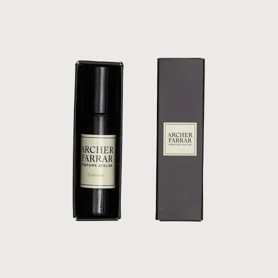 Two Archer Parker perfume bottles and their packaging on a textured beige surface