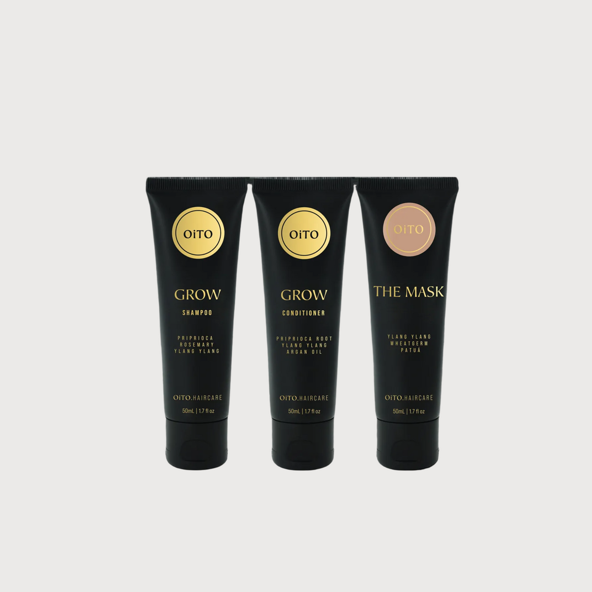 Three black hair care products with gold labels on a white background
