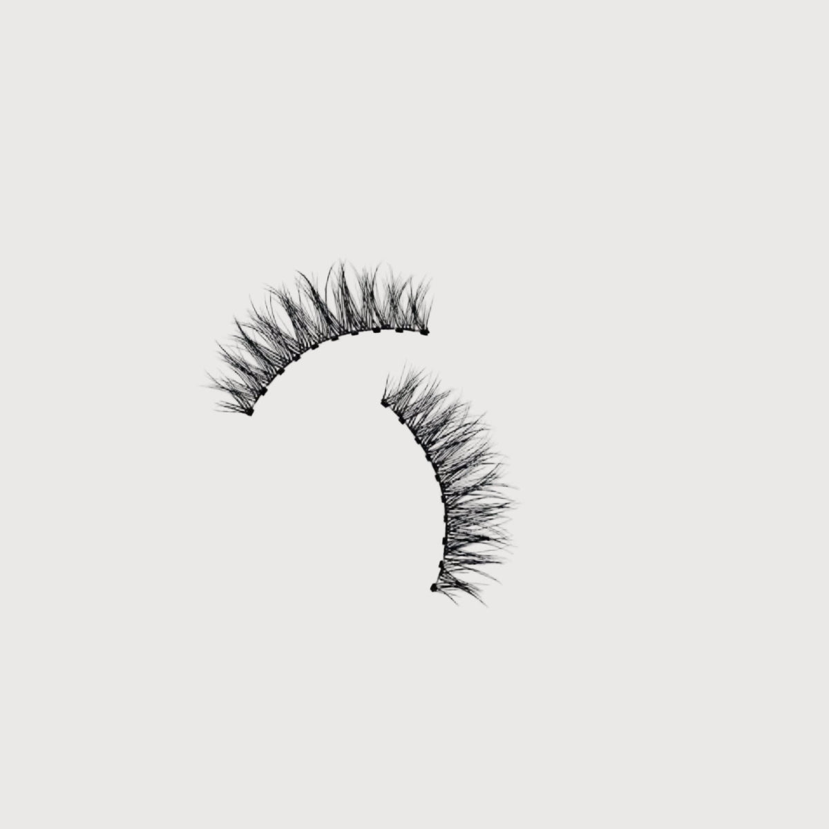 Pair of false eyelashes on a light gray background