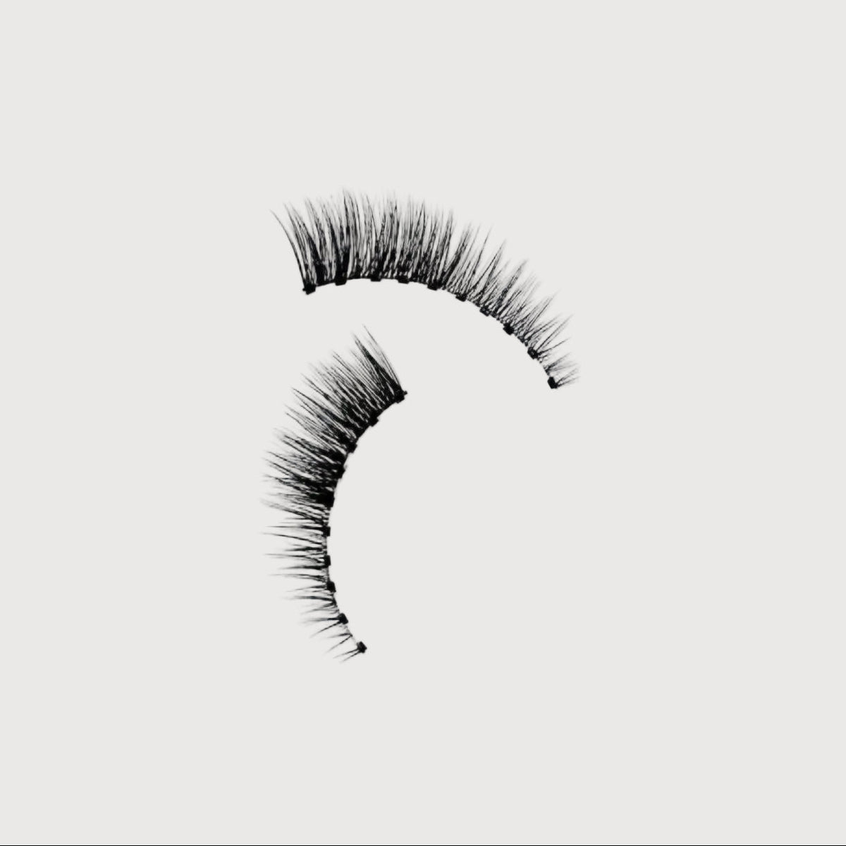 Pair of false eyelashes on a light gray background