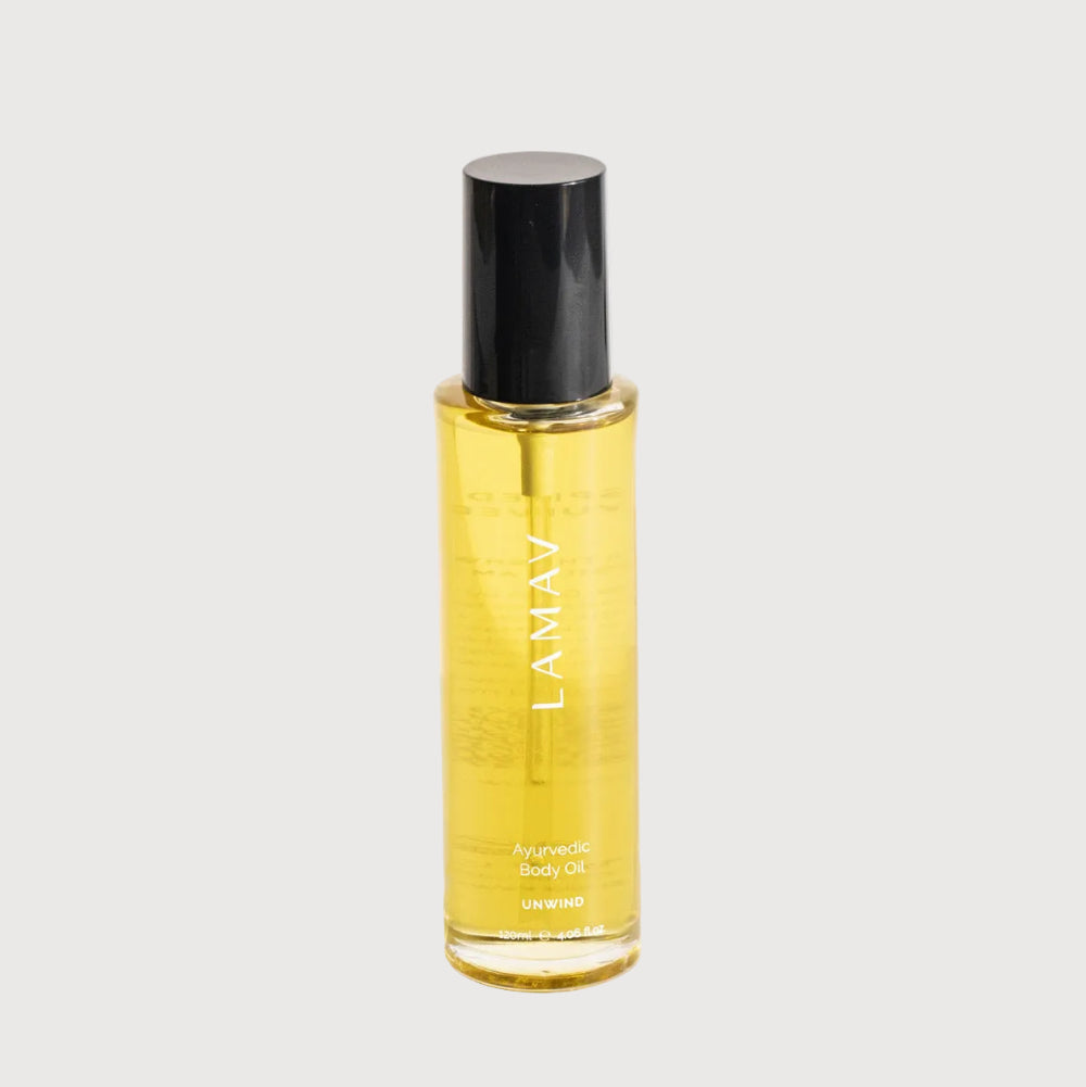 Yellow bottle of LAMAV body oil on a white background