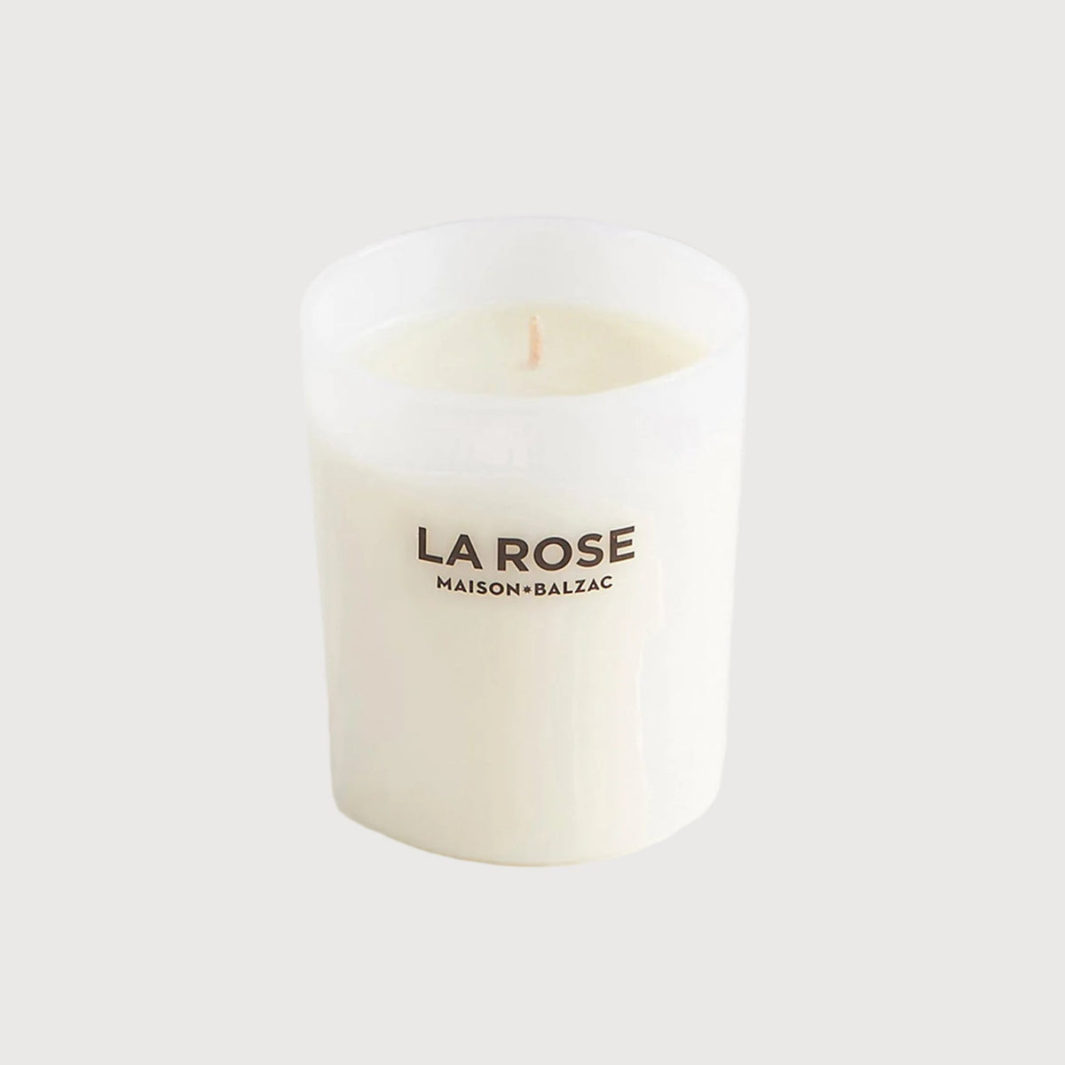 White candle with 'LAROSE' branding on a light gray background