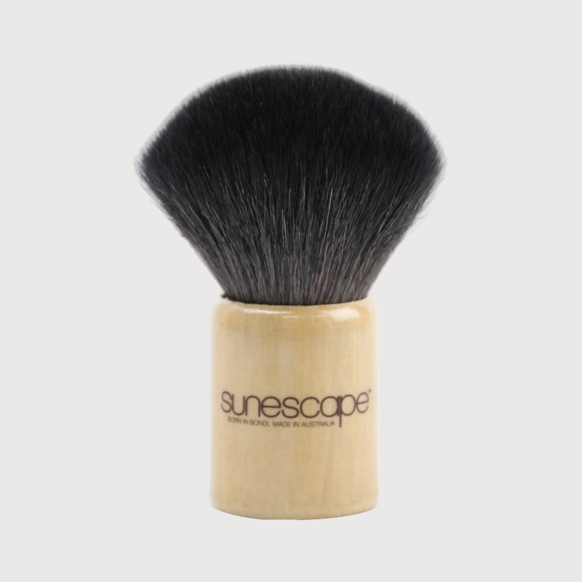 Makeup brush with black bristles and wooden handle on a white background, branded 'sunescapes'.